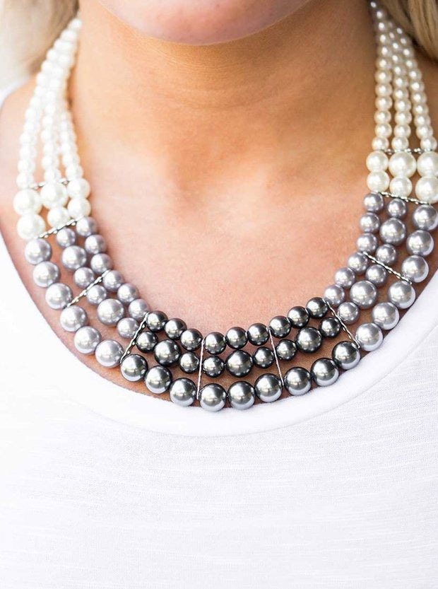 Strands of white, silver, and dark gray pearls elegantly drape below the collar, creating a beautiful hombre effect. Sectioned by silver accents, the luminescent pearls radiantly fall into a glamorous cascade. Features an adjustable clasp closure.  Sold as one individual necklace. Includes one pair of matching earrings.