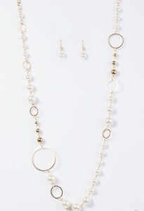 Luminescent pearls and classic gold beads join shimmery gold hoops along a gold chain for a timeless look. Features an adjustable clasp closure.  Sold as one individual necklace. Includes one pair of matching earrings.