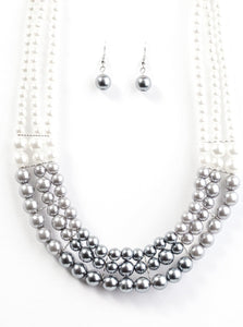 Strands of white, silver, and dark gray pearls elegantly drape below the collar, creating a beautiful hombre effect. Sectioned by silver accents, the luminescent pearls radiantly fall into a glamorous cascade. Features an adjustable clasp closure.  Sold as one individual necklace. Includes one pair of matching earrings.