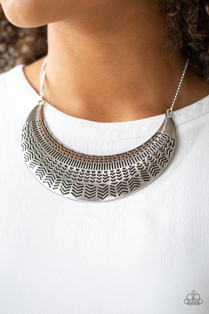 Stamped in an assortment of geometric patterns, an oversized silver half-moon pendant swings below the collar for a bold tribal style. Features an adjustable clasp closure.  Sold as one individual necklace. Includes one pair of matching earrings. Always nickel and lead free.