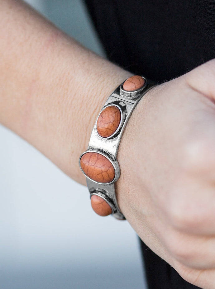 Chiseled into smooth ovals, smooth brown stone beads are pressed into an antiqued silver cuff for a handcrafted, artisanal look.  Sold as one individual bracelet.