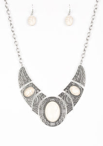 Radiating with studded and tribal inspired patterns, antiqued silver plates connect below the collar for a fierce look. Refreshing white stones are pressed into the plates, adding an artisan flair to the dramatic centerpiece. Features an adjustable clasp closure.  Sold as one individual necklace. Includes one pair of matching earrings