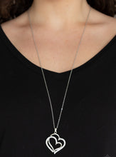 Load image into Gallery viewer, Encrusted in sections of glittery white rhinestones, two glistening silver hearts delicately join at the bottom of a lengthened silver chain for a charming look. Features an adjustable clasp closure.  Sold as one individual necklace. Includes one pair of matching earrings. 