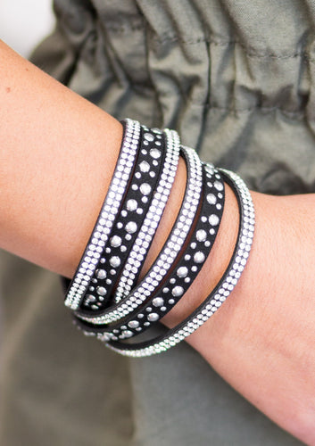 Bubbly silver studs, and rows of glittery white rhinestones are encrusted along strips of black suede. The elongated design allows for a trendy double wrap around the wrist. Features an adjustable snap closure.  Sold as one individual bracelet.