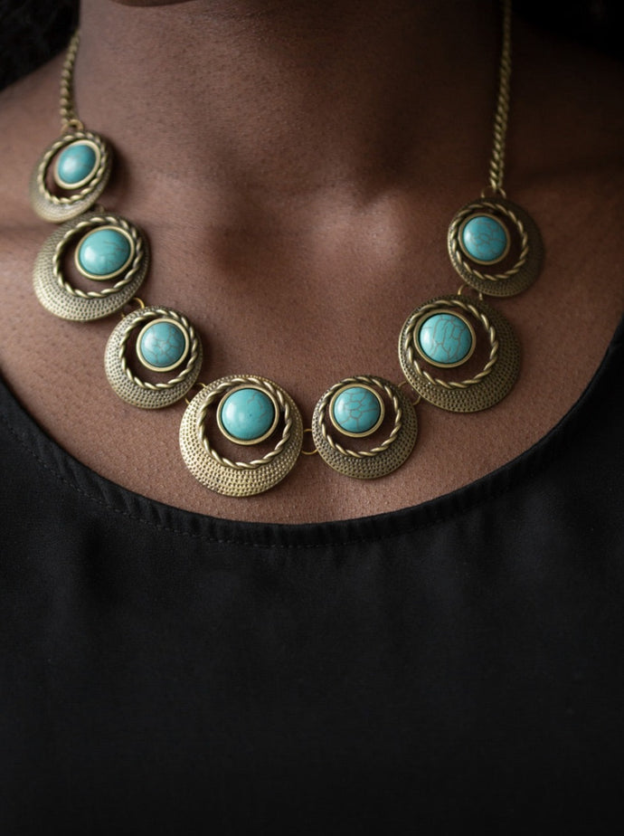 ﻿Featuring refreshing turquoise stone accents, hammered and textured circular frames link below the collar for an artisan inspired look. Features an adjustable clasp closure.  Sold as one individual necklace. Includes one pair of matching earrings.