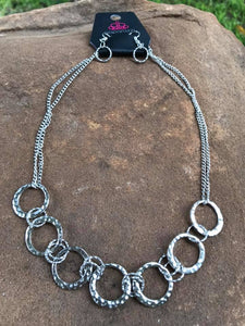 Delicately hammered in light-catching shimmer, silver hoops link below the collar for a fierce fashion. Features an adjustable clasp closure.  Sold as one individual necklace. Includes one pair of matching earrings.  Always nickel and lead free.