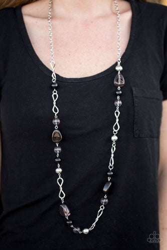 Black and polished black beading trickles along a shimmery silver chain. Classic silver beads and twisting silver accents are sprinkled between the colorful beading, adding shimmery hints to the whimsical palette. Features an adjustable clasp closure.  Sold as one individual necklace. Includes one pair of matching earrings.