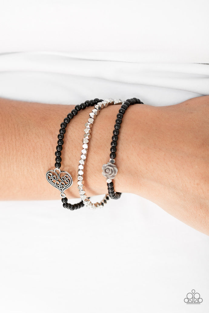 Featuring a gray resin rose and a shimmery silver heart charm, dainty black beads and faceted silver beads are threaded along stretchy bands for a vintage inspired look.  Sold as one set of three bracelets.  Always nickel and lead free.