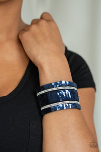 Infused with strands of blinding white rhinestones, row after row of shimmery sequins are stitched across the front of a spliced black suede band. Bracelet features reversible sequins that change from silver to blue. Features an adjustable snap closure.  Sold as one individual bracelet.  Always nickel and lead free.