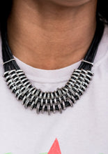 Load image into Gallery viewer, Bold and unapologetic, this hefty necklace gives off a hand-made feel with its multiple strands of black cording held together by industrial silver fittings that shift and slide. Features an adjustable clasp closure.