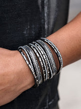 Load image into Gallery viewer, A thick black suede band is spliced into several smaller bands and encrusted in row after row of glassy white rhinestones, smoky hematite rhinestones, and flat silver accents for a sassy look. Features an adjustable snap closure.