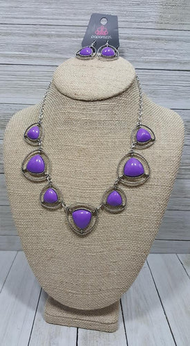 Bubbly purple beads pressed into sleek triangular silver frames link together to form a vivacious statement piece that beautifully cascades down the chest. Features an adjustable clasp closure.  Sold as one individual necklace. Includes one pair of matching earrings.  Exclusive