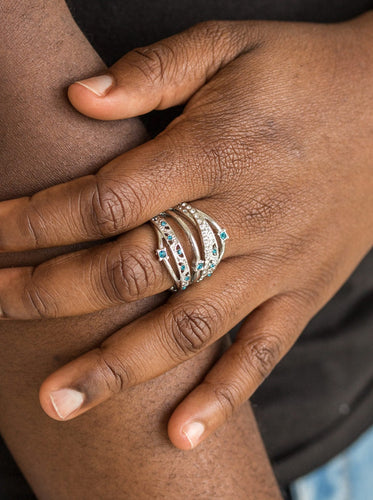 Mismatched silver bands arc across the finger, coalescing into an airy frame. Dainty blue and white rhinestones are sporadically sprinkled across the shimmery layers for a refined finish. Features a stretchy band for a flexible fit.  Sold as one individual ring.