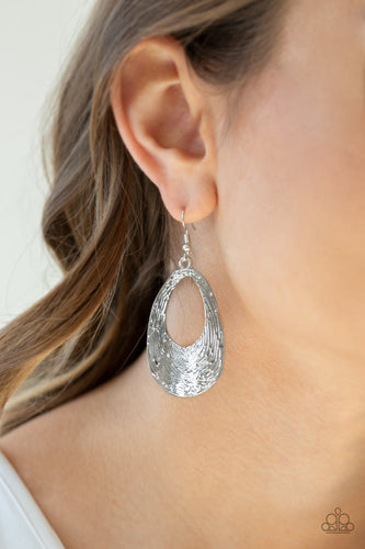 Rippling with tactile texture, an abstract silver teardrop swings from the ear for a casual look. Earring attaches to a standard fishhook fitting.  Sold as one pair of earrings.  Always nickel and lead free..