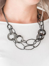 Load image into Gallery viewer, Mismatched gunmetal rings and hoops link below the collar in bold layers for a spunky industrial look. Features an adjustable clasp closure.  Sold as one individual necklace. Includes one pair of matching earrings. 