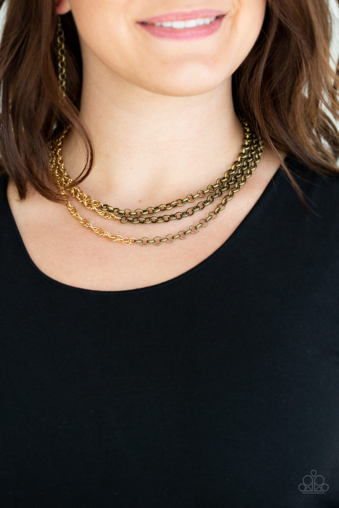 Strung between two brass fittings, glistening brass chains collide with shimmery gold chains below the collar, creating edgy mixed metallic layers. Features an adjustable clasp closure.  Sold as one individual necklace. Includes one pair of matching earrings.  Always nickel and lead free. 
