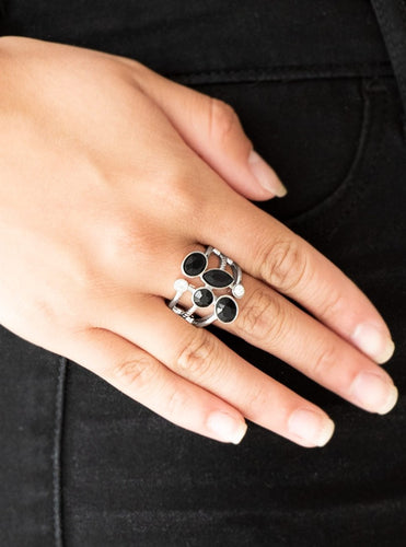 Varying in shape and cut, glassy white rhinestones and glittery black rhinestones tumble down the center of layered silver bands for an edgy look. Features a stretchy band for a flexible fit.  Sold as one individual ring.  Always nickel and lead free.