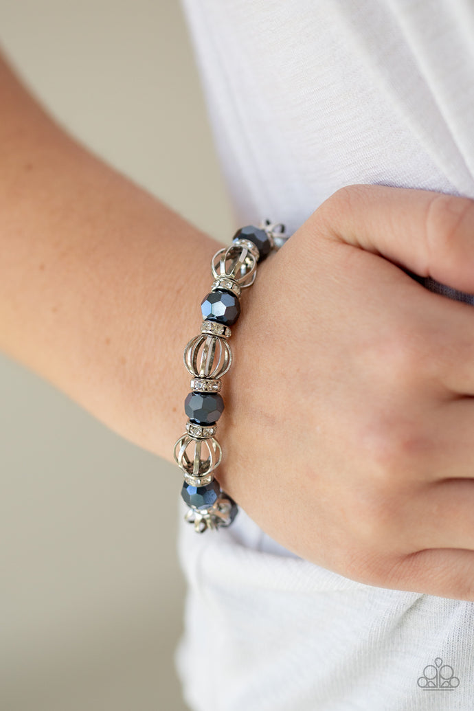 A collection of airy silver beads, faceted blue metallic beads, and white rhinestone encrusted rings are threaded along a stretchy band around the wrist for a glamorous look.  Sold as one individual bracelet. ﻿Always nickel and lead free.