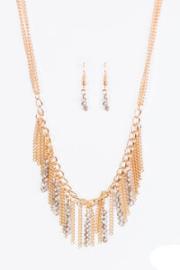 Threaded along metallic rods, stacks of smoky beading trickle from the bottom of a gold chain. The glittery accents trickle between trestles of gold chains, creating a fierce fringe below the collar. Features an adjustable clasp closure.  Sold as one individual necklace. Includes one pair of matching earrings.