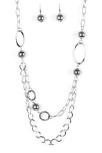 Load image into Gallery viewer, Dramatic gunmetal accents trickle along bold silver chains, creating an edgy mixed metallic palette across the chest. Features an adjustable clasp closure.  Sold as one individual necklace. Includes one pair of matching earrings.