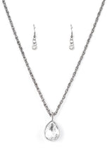 Load image into Gallery viewer, A white teardrop gem is pressed into a sleek gunmetal frame, creating a bold 3-dimensional pendant below the collar. Features an adjustable clasp closure.  Sold as one individual necklace. Includes one pair of matching earrings.