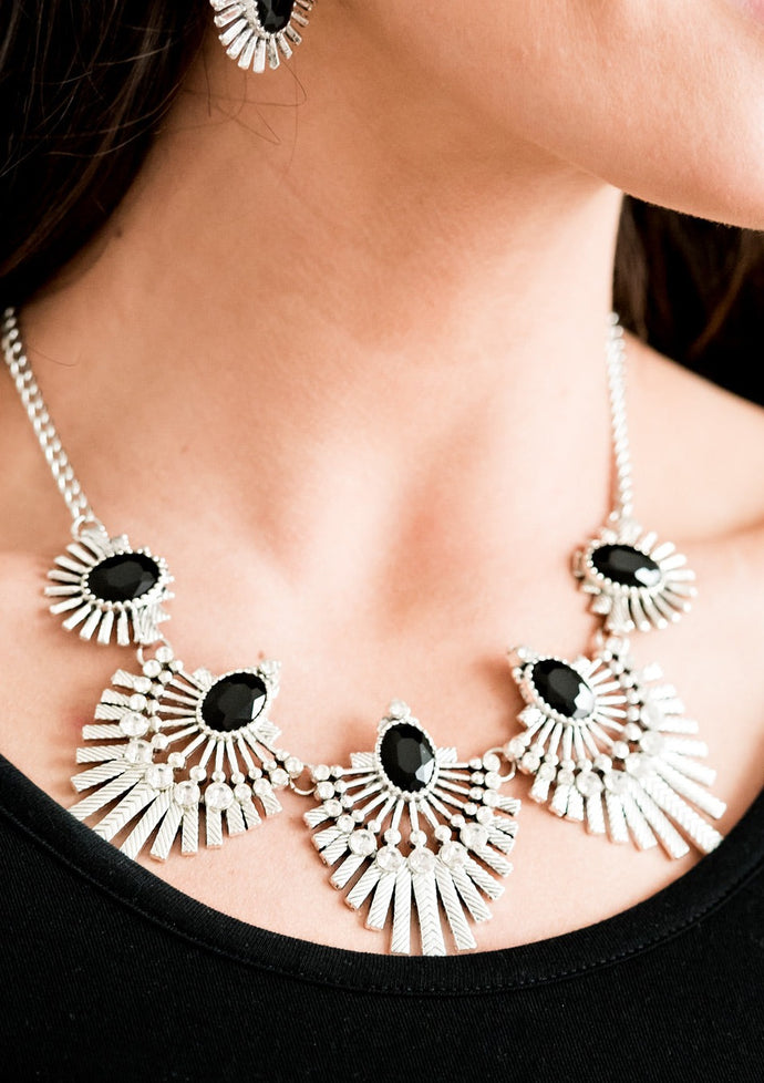 Textured metal bars flare out from a mesmerizing black gem, creating a fringe of fanning frames. Sprinkled with white rhinestones, the dazzling display falls just below the collar for a sassy finish. Features an adjustable clasp closure  Sold as one individual necklace. Includes one pair of matching earrings.