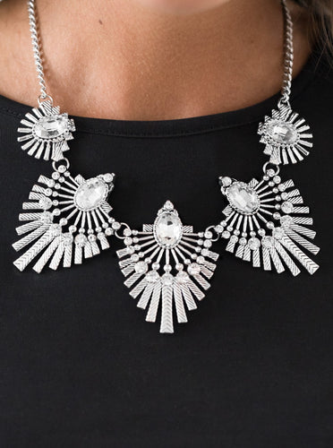 Textured metal bars flare out from a mesmerizing gem, creating a fringe of fanning frames. Sprinkled with matching white rhinestones, the dazzling display falls just below the collar for a sassy finish. Features an adjustable clasp closure.  Sold as one individual necklace. Includes one pair of matching earrings.