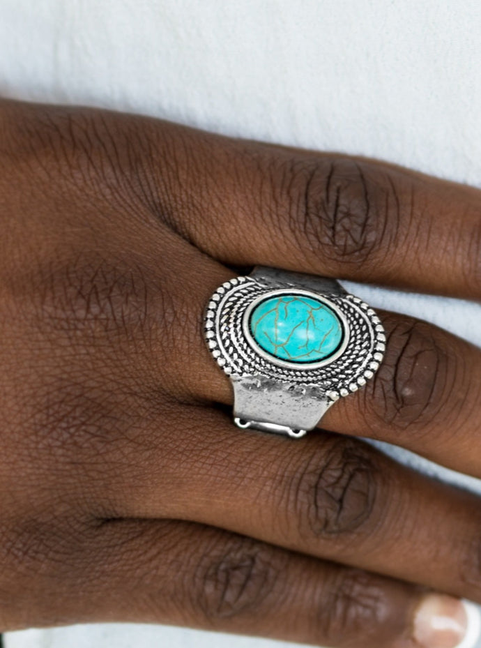 A refreshing turquoise stone is pressed into the center of an antiqued silver frame radiating with studded and rope-like textures for an artisan inspired look. Features a stretchy band for a flexible fit.  Sold as one individual ring.