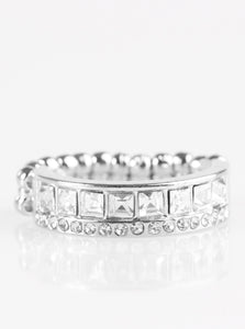 Featuring edgy square cuts, a row of glittery white rhinestones are encrusted along a glistening silver band. Dainty white rhinestones are encrusted along the top of the band, adding classic shimmer to the sassy palette. Features a dainty stretchy band for a flexible fit.  Sold as one individual ring.