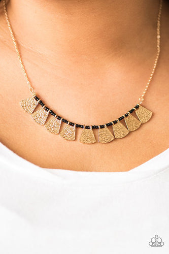 Embossed in wavy textures, shimmery gold plates swing from the bottom of a strand of dainty black beading, creating a colorful fringe below the collar. Features an adjustable clasp closure.  Sold as one individual necklace. Includes one pair of matching earrings.   Always nickel and lead free.