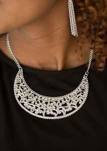 Silver vine-like filigree climbs a crescent shaped frame, creating a dramatic pendant below the collar. Features an adjustable clasp closure.  Sold as one individual necklace. Includes one pair of matching earrings.  