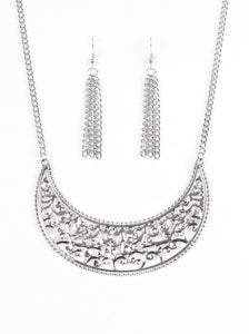 Silver vine-like filigree climbs a crescent shaped frame, creating a dramatic pendant below the collar. Features an adjustable clasp closure. Sold as one individual necklace. Includes one pair of matching earrings.