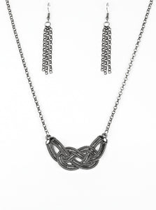 Featuring chain-like patterns, antiqued gunmetal bars knot below the collar for a bold industrial look. Features an adjustable clasp closure.  Sold as one individual necklace. Includes one pair of matching earrings.