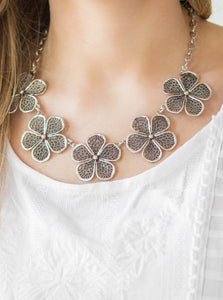 Featuring lace-like petals, glistening silver daisies link below the collar for a seasonal look. Features an adjustable clasp closure.  Sold as one individual necklace. Includes one pair of matching earrings.