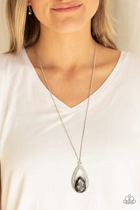 A smoky teardrop gem is pressed into a silver frame radiating with glassy white rhinestones. The glamorous pendant swings from the bottom of a shimmery silver chain for a refined look. Features an adjustable clasp closure.  Sold as one individual necklace. Includes one pair of matching earrings.  