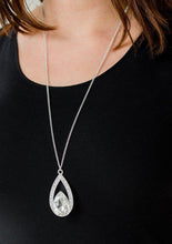 Load image into Gallery viewer, A glittery white teardrop gem is pressed into a silver frame radiating with glassy white rhinestones. The glamorous pendant swings from the bottom of a shimmery silver chain for a refined look. Features an adjustable clasp closure.  Sold as one individual necklace. Includes one pair of matching earrings.  Always nickel and lead free.