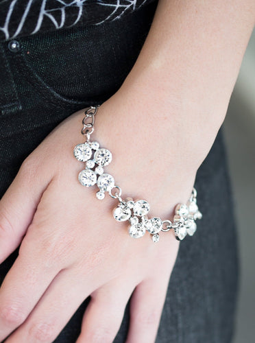 Clusters of brilliant white rhinestones drape elegantly along the wrist. The scattered pattern and varying sizes of the rhinestones add breathtaking detail to the piece. Features an adjustable clasp closure.  Sold as one individual bracelet.