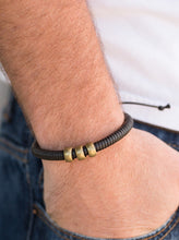Load image into Gallery viewer, Shiny black twine wraps around a black cord, creating an urban look around the wrist. Shiny brass beads slide along the cording for a rugged finish. Features an adjustable sliding knot closure.  Sold as one individual bracelet.