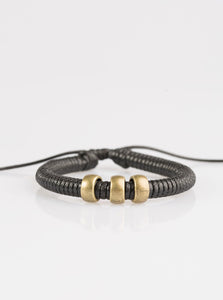 Shiny black twine wraps around a black cord, creating an urban look around the wrist. Shiny brass beads slide along the cording for a rugged finish. Features an adjustable sliding knot closure.  Sold as one individual bracelet.
