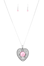 Load image into Gallery viewer, Featuring a glowing pink moonstone center, an over-sized heart frame radiating with silver filigree and glittery white rhinestones swings from the bottom of a lengthened silver chain for a whimsical look. Features an adjustable clasp closure.  Sold as one individual necklace. Includes one pair of matching earrings.