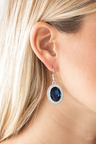 An over-sized blue gem is pressed into the center of a silver frame radiating with glassy white rhinestones for a glamorous look. Earring attaches to a standard fishhook fitting.  Sold as one pair of earrings.  Always nickel and lead free. 