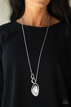 Load image into Gallery viewer, A faceted white gem is nestled inside of a shimmery silver frame encrusted in dainty white rhinestones. The glittery pendant asymmetrically links with abstract silver frames at the bottom of a lengthened silver rounded snake chain for a modern look. Features an adjustable clasp closure.  Sold as one individual necklace. Includes one pair of matching earrings.  Always nickel and lead free.