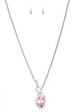 Load image into Gallery viewer, A faceted pink gem is nestled inside of a shimmery silver frame encrusted in dainty white rhinestones. The glittery pendant asymmetrically links with abstract silver frames at the bottom of a lengthened silver rounded snake chain for a modern look. Features an adjustable clasp closure.  Sold as one individual necklace. Includes one pair of matching earrings.
