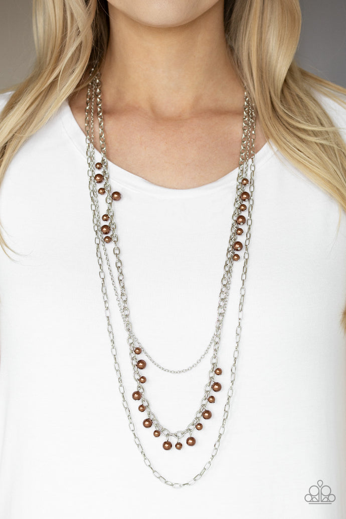 Three mismatched silver chains layer down the chest. Dainty brown pearls cascade down one silver chain, adding a flirty twist to the timeless pearl palette. Features an adjustable clasp closure.  Sold as one individual necklace. Includes one pair of matching earrings.  Always nickel and lead free.