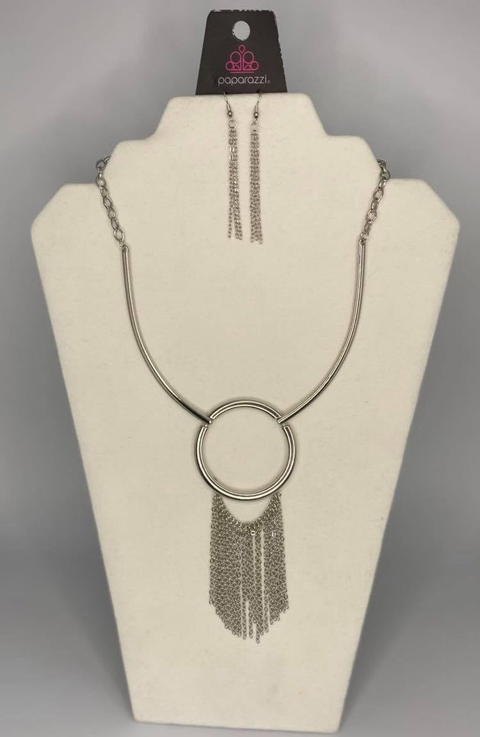 Attached to two bowing shiny silver bars, a shiny silver hoop gives way to a matching chain fringe, creating a statement-making look below the collar. Features an adjustable clasp closure.  Sold as one individual necklace. Includes one pair of matching earrings.  Always nickel and lead free.  Fashion Fix February 2021 Exclusive