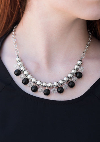 Infused with a bold silver chain, classic silver beads are threaded along a skinny wire below the collar. Polished black and faceted crystal-like beads swing from the bottom of the silver beads, creating a refined fringe. Features an adjustable clasp closure.  Sold as one individual necklace. Includes one pair of matching earrings.