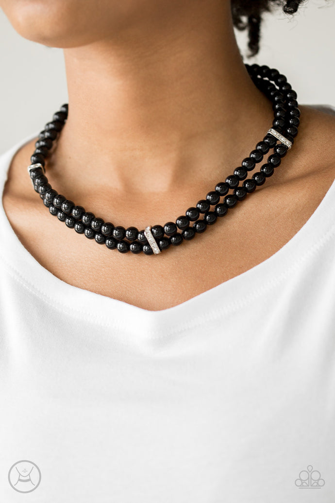 Pinched between white rhinestone encrusted frames, strands of classic black beads layer around the neck for a timeless look. Features an adjustable clasp closure.  Sold as one individual necklace. Includes one pair of matching earrings.  Always nickel and lead free.