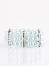 Load image into Gallery viewer, Classic blue pearls are threaded along elastic stretchy bands, creating colorful layers across the wrist. Encrusted in glittery white rhinestones, shimmery silver frames fit around the pearl strands, joining the bracelets.  Sold as one individual bracelet.