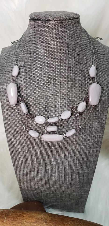 Infused with dainty metallic accents, a collection of silver gray and sparkling crystal-like beads are threaded along invisible wires below the collar for a whimsically layered look. Features an adjustable clasp closure.  Sold as one individual necklace. Includes one pair of matching earrings.  Always nickel and lead free.  Fashion Fix Exclusive April 2020