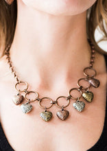 Load image into Gallery viewer, Stamped in whimsical patterns, vintage inspired brass, copper and silver hearts cascade from the bottom of airy copper hoops, creating a romantic fringe below the collar. Features an adjustable clasp closure.  Sold as one individual necklace. Includes one pair of matching earrings.